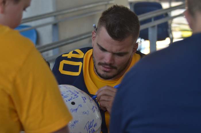 West Virginia linebacker Wil Schoonover signing autographs at WVU Fan Day.